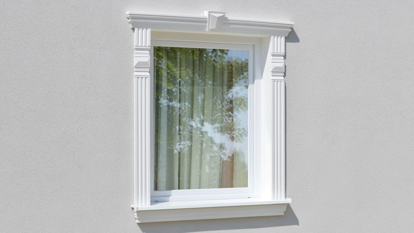 Elegáns homlokzatkialakítás modern ablakstukkóval